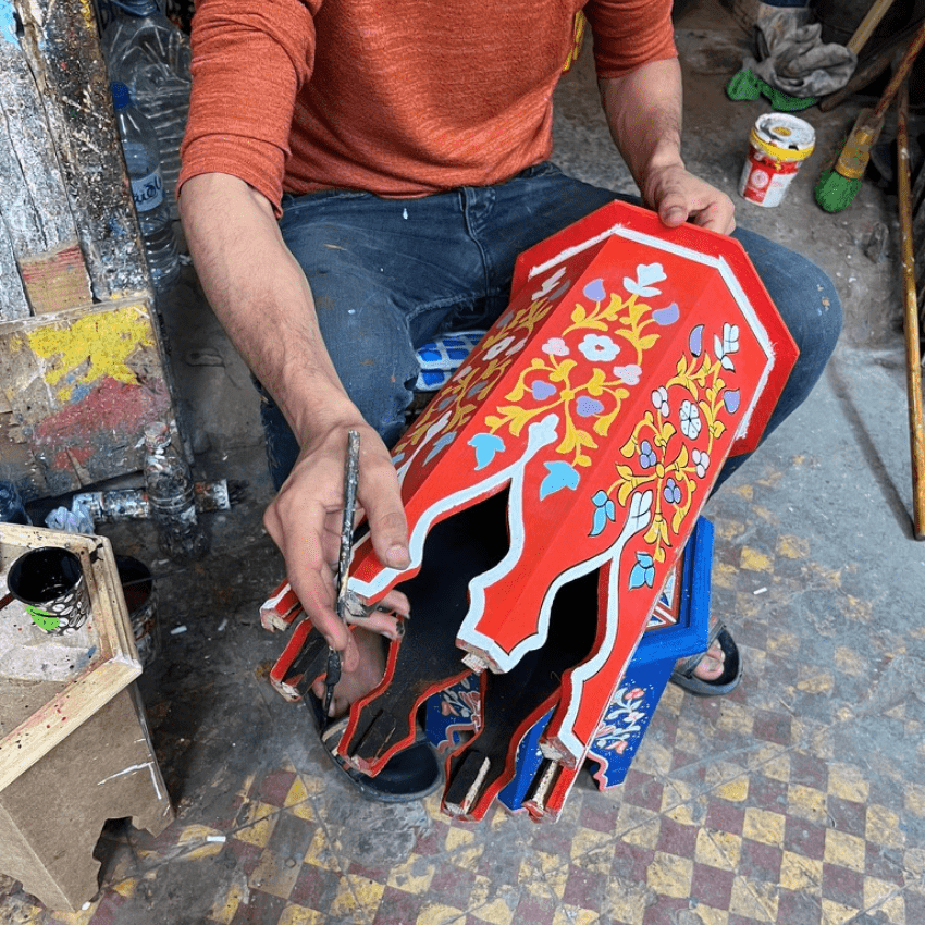 Craftsman painting an octagonal coffee tables wood​